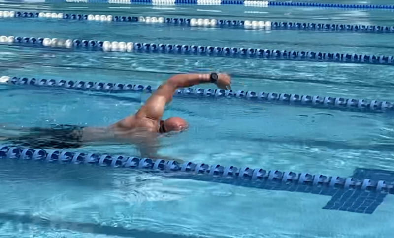 Don Milich swimming laps in a pool with swimming lanes