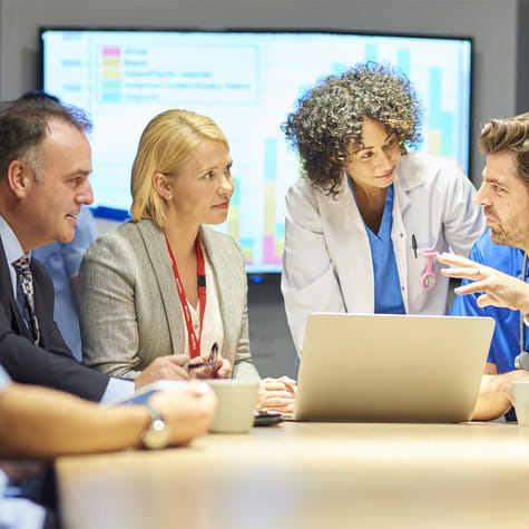 Diverse team meeting around a laptop