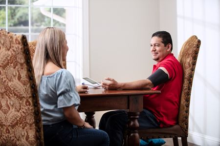 husband and wife at table checking blood pressure