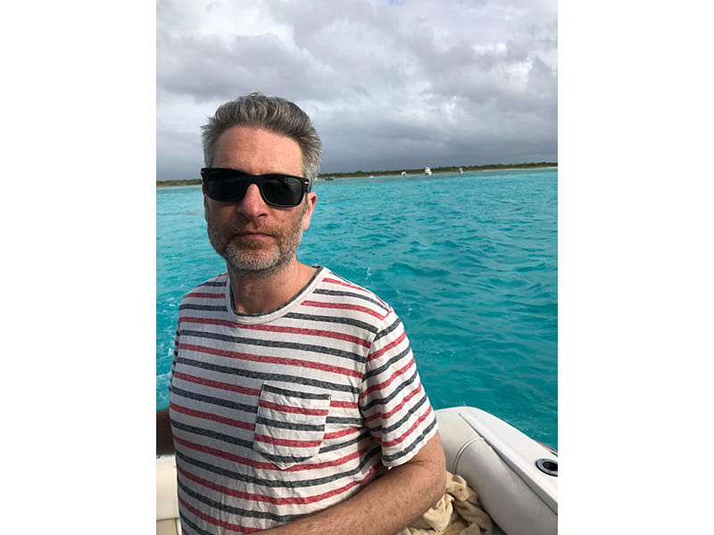 Aaron Holm wearing sunglasses, on a boat on the water