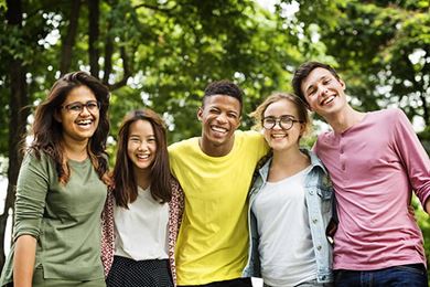 Young adult students smiling and posing together outside